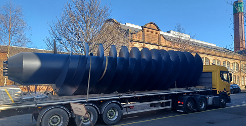 A giant screw pump is shown arriving at McDonald Road on the back of a wagon